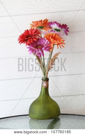 Bogus Flowers In The Bottle On Coffee Table.