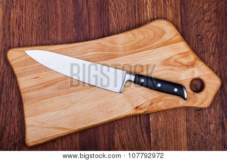 Knife on cutting boardon a woodwn table