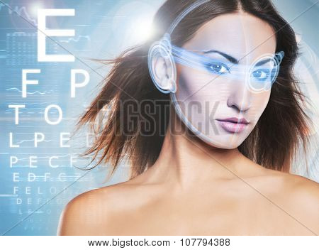 Beautiful woman with laser hologram and test vision table over cyan background.