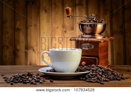 still life with coffee beans and old coffee mill on the wooden background  
