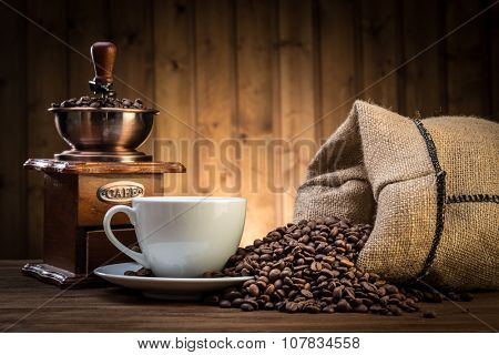 still life with coffee beans and old coffee mill on the wooden background  