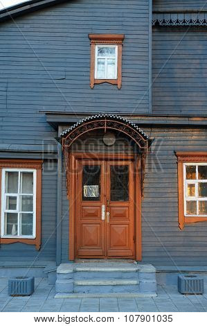 Steel Colored Wooden House Facade With Brown Closed Door And Windows