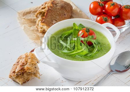 Arugula and tomatoes puree soup in white bowl
