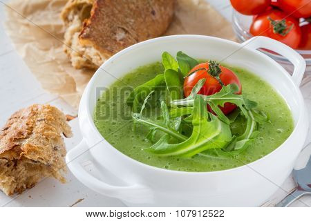 Arugula and tomatoes puree soup in white bowl