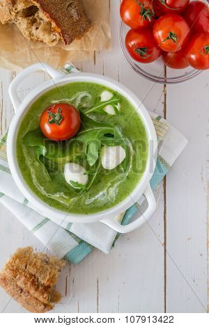 Arugula and tomatoes puree soup in white bowl