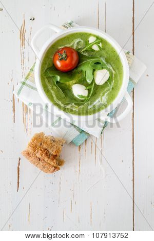 Arugula and tomatoes puree soup in white bowl