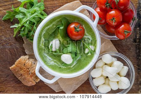 Arugula and tomatoes puree soup in white bowl