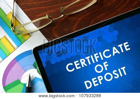Tablet with certificate of deposit (CD) on a table.