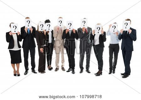 Business Team Hiding Faces With Question Mark Signs