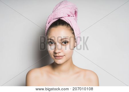 girl after shower with a towel on her head looking at the camera, isolated