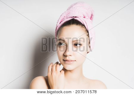 girl after shower with a towel on her head looking to the side, isolated