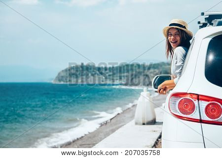 Rear view of pre teen child in car over sea view on summer roadtrip to the beach