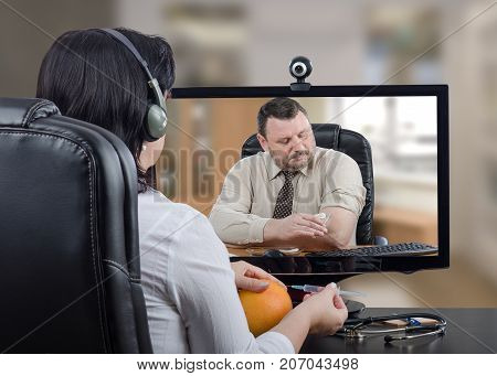Telemedicine general practitioner teaching businessman how to do self-vaccination against influenza. Virtual female doc in headset uses grapefruit for training purpose