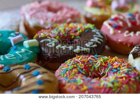Sweet beautiful bright tasty delicious donuts with colorful glaze and a congratulatory inscription "Birthday"
