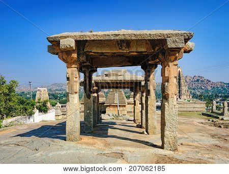 View of ancient ruins on Hemakuta hill in Hampi, Karnataka, India. Landscape with unique mountain formation with amazing stones, tropical nature and temple. UNESCO World Heritage Site