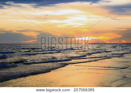 Dramatic sky at sunset or evening time over sea or ocean with golden or orange light tone.