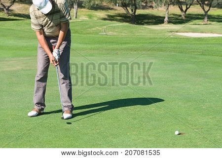 A golfer  he trains   playing in a tournament