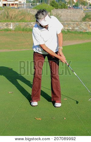 A golfer  he trains   playing in a tournament
