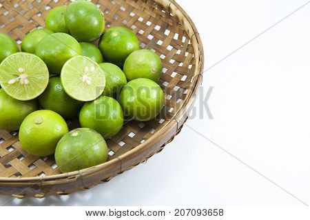 Closeup of fresh lime green slice in basket isolated on white background.