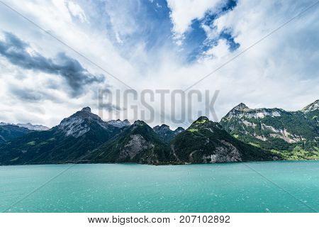 The wind over the mountains and the lake brought cumulus and thunderclouds. Lake Lucerne with Oberbauenstock (2116m) Niderbauen-Chulm. Switzerland.