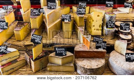 Paris France - Jule 09 2017: A large selection of different french and italian cheeses on the counter of a small store at the Aligre Market (Marche d'Aligre) in the Bastille district.