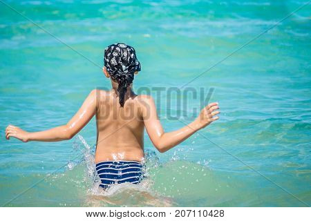 Cyprus young caucasian boy jump in water Mediterranean Sea swim with splash