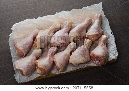 Fresh raw chicken legs arrangement on a kitchen cutting board