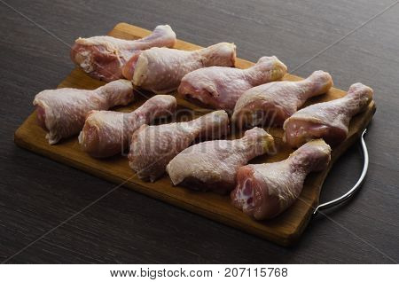 Fresh raw chicken legs arrangement on a kitchen cutting board