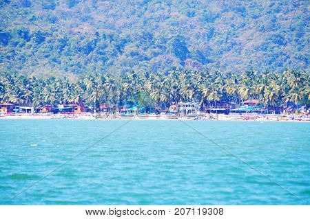 Palolem beach, South Goa, India. One of the best beaches in Goa. Colorful beach huts and palm trees on the coast. Luxury leisure.