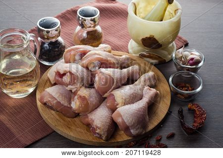 Fresh raw chicken legs arrangement on a kitchen cutting board