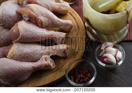 Fresh raw chicken legs arrangement on a kitchen cutting board