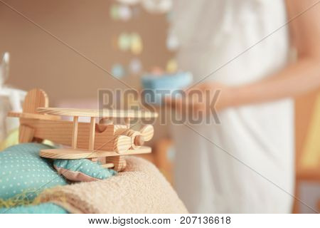 Toy airplane and blurred pregnant woman on background