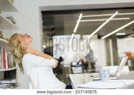 Businesswoman In The Office Taking A Break And Doing A Neck Exercise