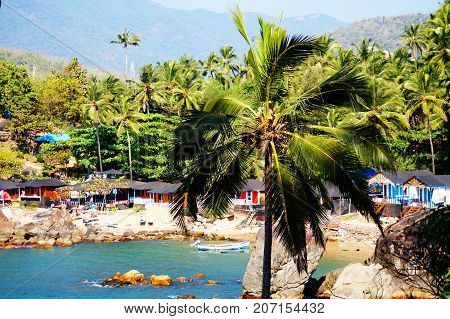 Palolem beach, South Goa, India. One of the best beaches in Goa. Colorful beach huts and palm trees on the coast. Luxury leisure.