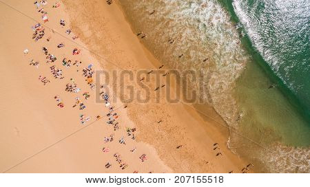 Aerial view of people resting on a beautiful beach near the ocean