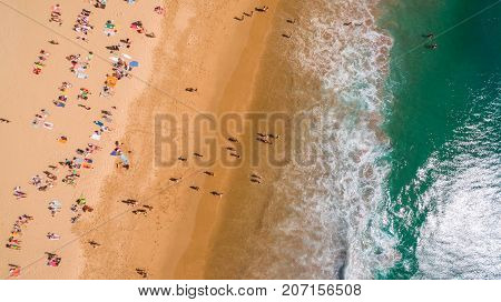 Aerial view of people resting on a beautiful beach near the ocean