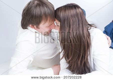 Cute Caucasian Couple Having an Interaction with Each Other While Looking Eyes To Eyes and Embracing On Floor. Horizontal Image Orientation