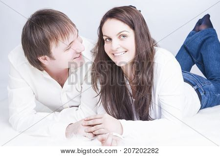 Cute and Loving Young Caucasian Couple Having Time Together. Communicating on Floor with Each Other and Holding Hands In Touch. Horizontal Image Composition