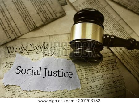 Social Justice news headline with gavel on a copy of the US Constitution