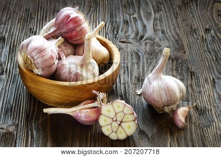 Garlic in a wooden bowl on the kitchen table