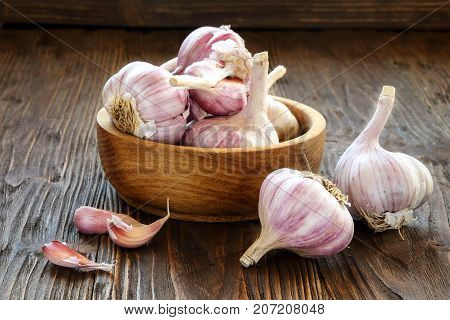 Garlic in a wooden bowl on the kitchen table