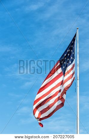 American flag waving on blue sky background in Key West USA on sunny day. National symbol citizenship and patriotism concept. Pride freedom and unity.