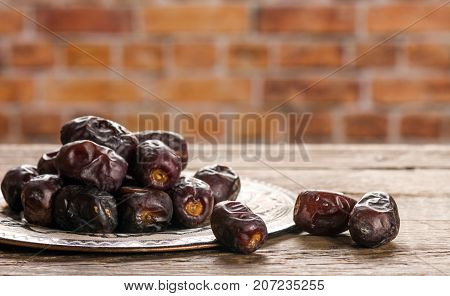 Fresh sweet dates on wooden background, close up