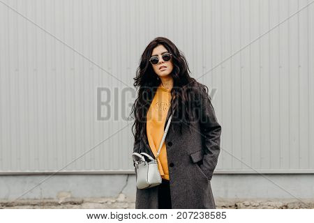 Portrait Of Stylish Modern Young Curly Woman In Coat Sunglasses. Trendy Hipster. Urban Life.