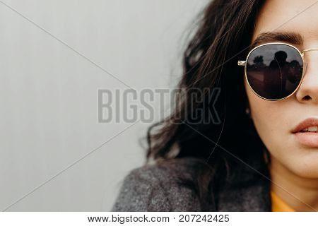 Portrait Of Stylish Modern Young Curly Woman In Coat Sunglasses. Part Of Face