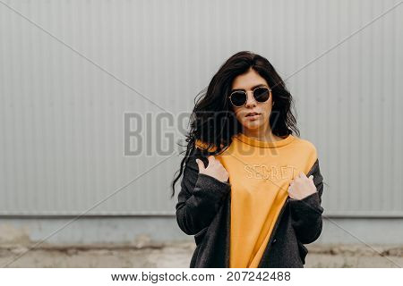 Portrait Of Stylish Modern Young Curly Woman In Coat Sunglasses