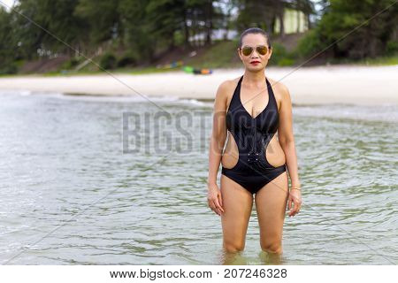 Woman black bikini show sexy symbol on beach at Ban Krut Beach Prachuap Khirikhan Province Thailand