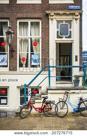 AMSTERDAM NETHERLANDS - JUNE 21 2016: Picture of a restaurant near Herengracht Canal with bicycles parking in the front in a cloudy day. Amsterdam Netherlands.