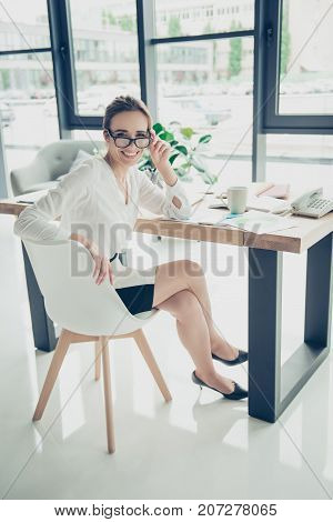 Successful Charming Relaxed Brown Haired Lawyer Is Enjoying Beverage At Her Work Station, In Smart O
