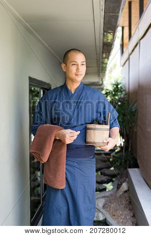 Onsen series: Asian man holding wooden bucket in ryokan